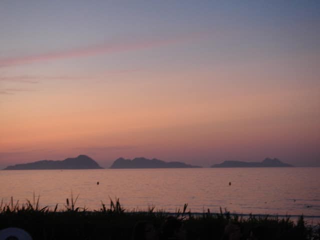 Galicia, Spain: from blue flags to green pastures. Sunset over the Cies Islands, Atlantic Ocean. Puesta del sol, Islas Cíes, Playa de Patos.