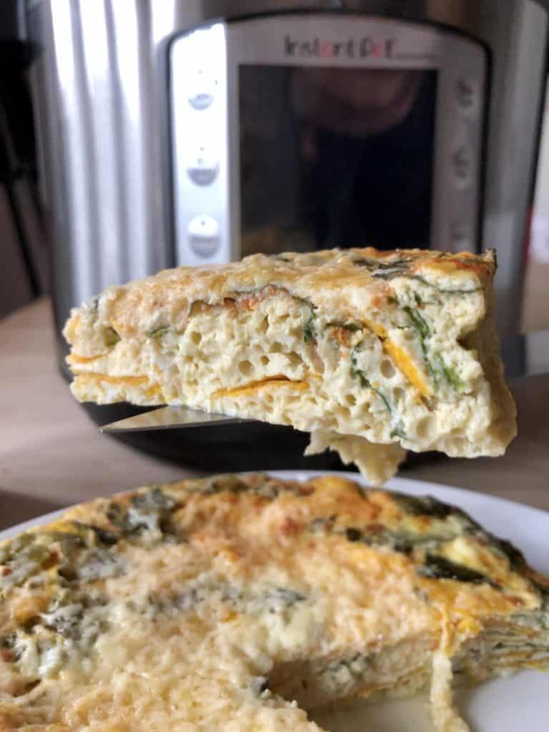 A slice of Instant Pot Chard and Sweet Potato Frittata with the Instant Pot Duo Evo Plus in the background