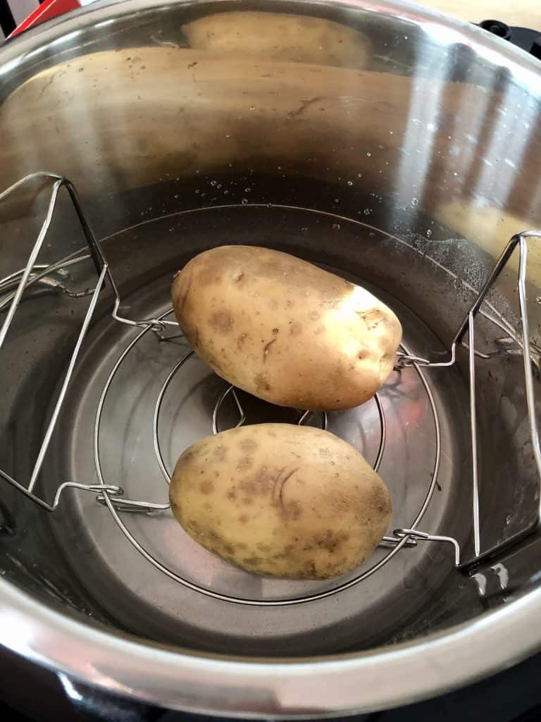 Instant Pot Duo Crisp jacket potatoes ready to cook on lower setting of trivet