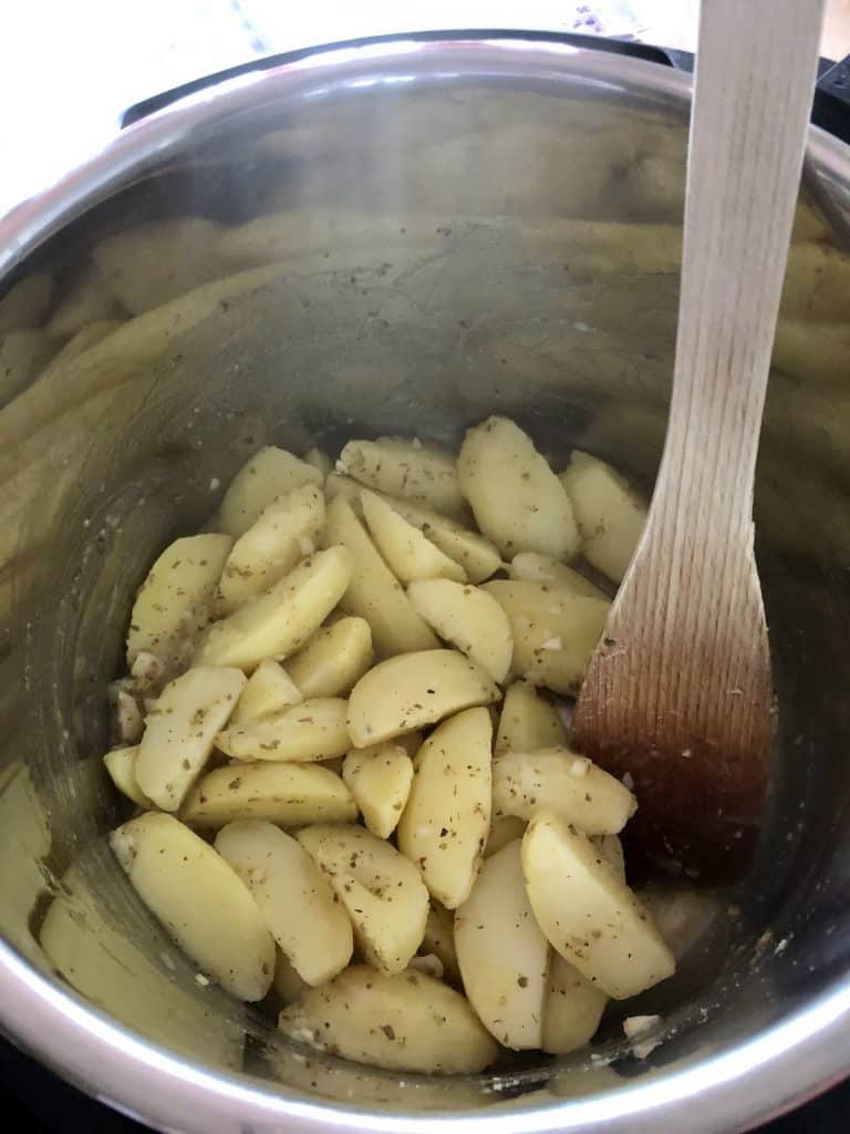 After mixing the wedges with the herbs after pressure cooking and before roasting the Greek Roast Potatoes in the Instant Pot