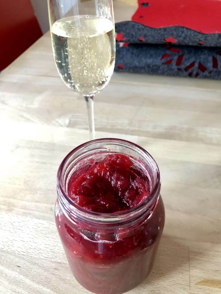 How to pressure cook Cranberry Sauce (with Instant Pot instructions) . in jar with glass of bubbly