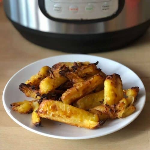 Photo of parsnips on a white plate in front of an Instant Pot Duo Crisp