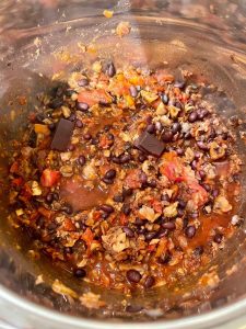 Mushroom chilli seen from above after pressure cooking, stirring and adding chocolate to melt