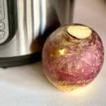 Photo of a Whole Swede or Rutabaga (uncooked) on a white textured surface, in front of an Instant Pot Duo