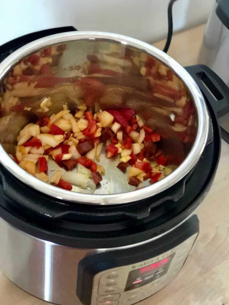 Image of the vegetables and the chorizo sautéing inside the inner pot of an Instant Pot Duo Mini 3 litres or 3 quart