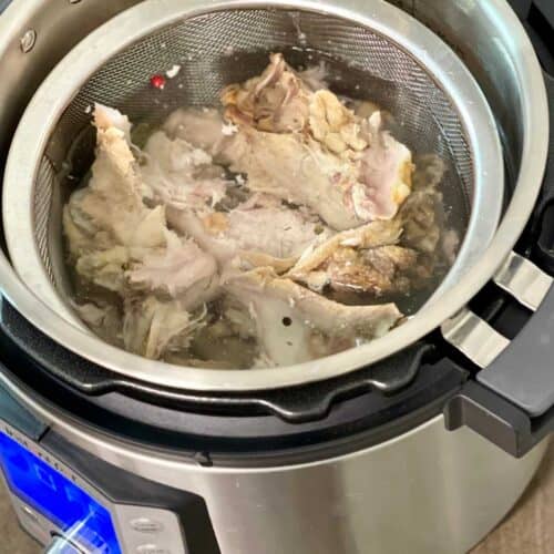 photo of turkey bones in mesh sieve seen from the top inside an Instant Pot Duo Evo Plus - for pressure cooker turkey stock