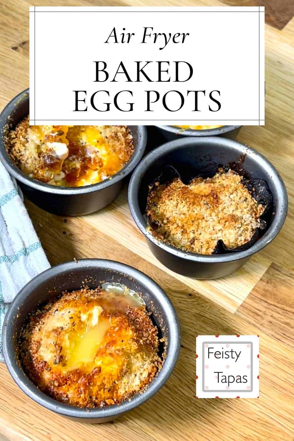 Air fried egg pots seen from above on a wooden chopping board with a white and green tea towel on the left. With the words Air Fryer Baked Egg Pots in black font against a white background rectangle