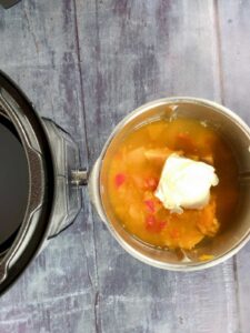 Photo of the thermomix bowl and an Instant Pot Duo Plus seen from above, the thermomix bowl has the pressure cooked veg and a dollop of cream cheese ready to blend