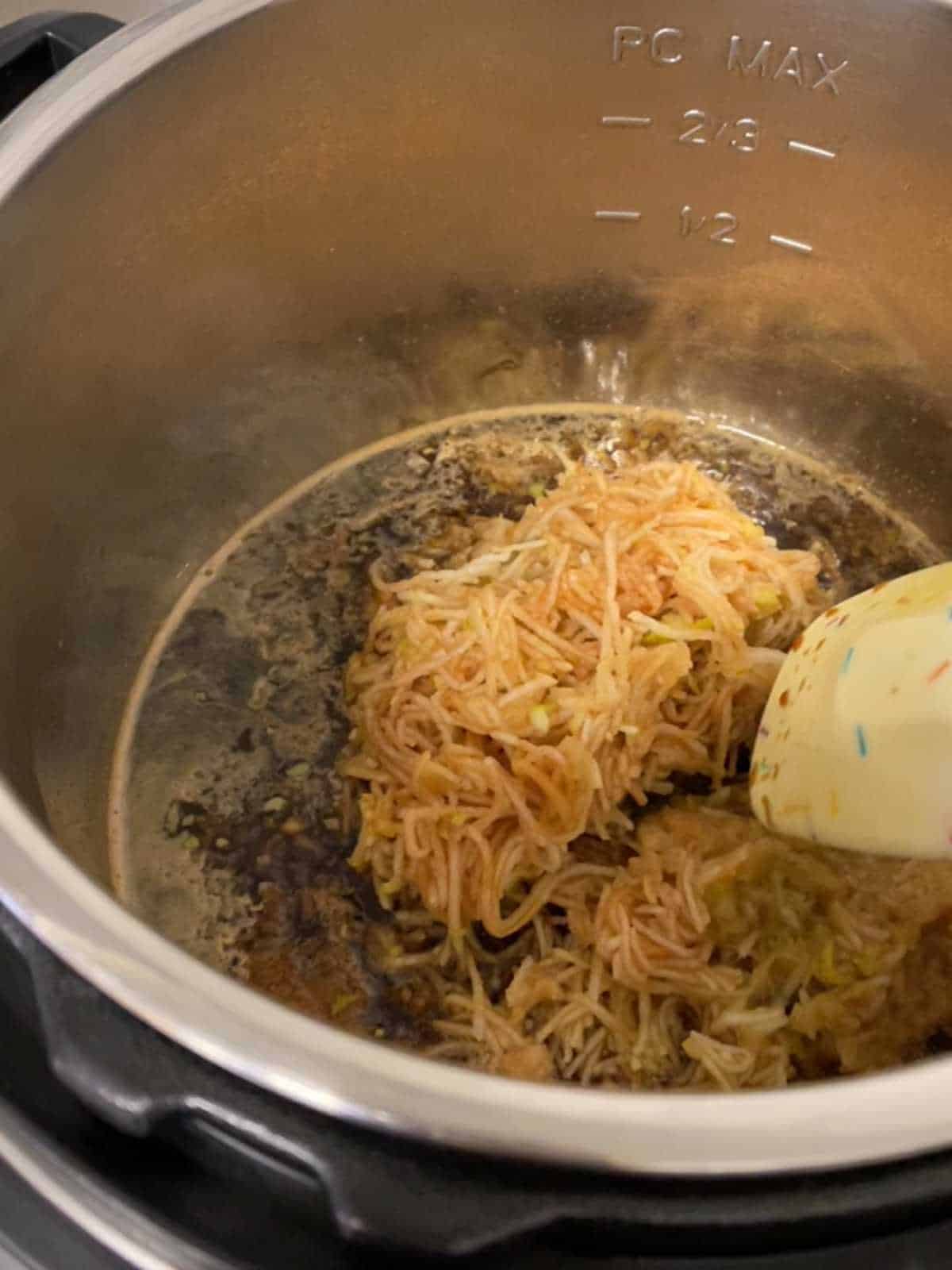 Photo of step 2 of the pressure cooker mincemeat recipe, stirring in the apple