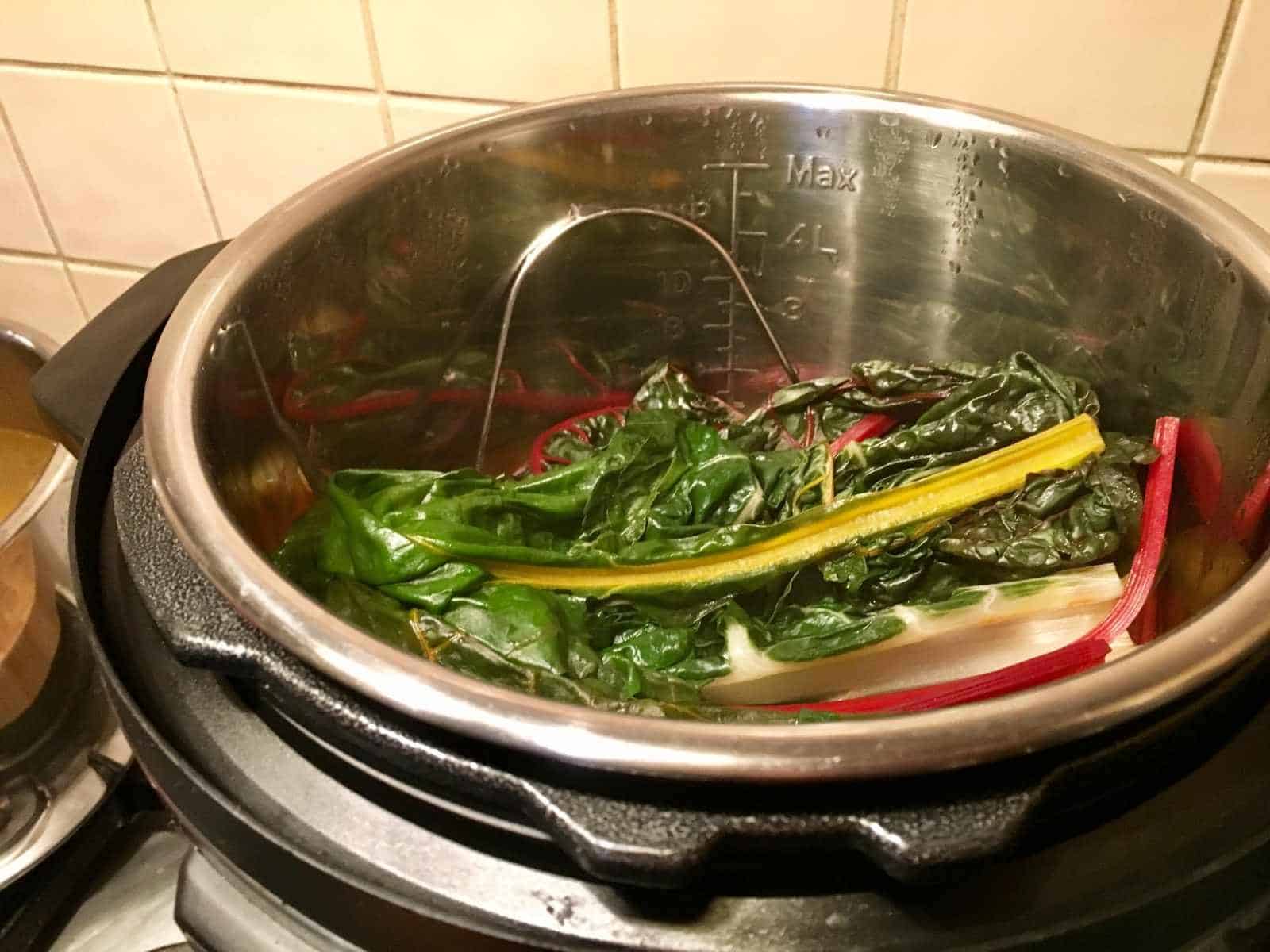 Photo of the chard sitting on top of the potatoes right after pressure cooking