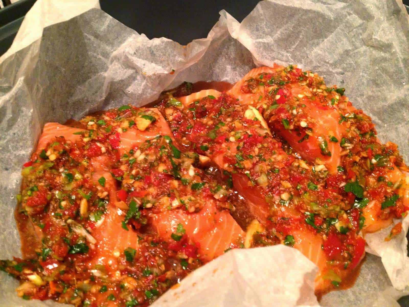 Photo of the raw salmon covered in the marinade ingredients, ready to cook