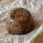 A Christmas Pudding sitting on the greaseproof paper it was previously wrapped in