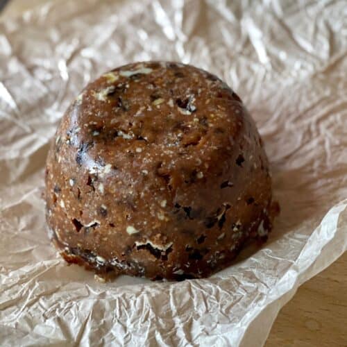 A Christmas Pudding sitting on the greaseproof paper it was previously wrapped in