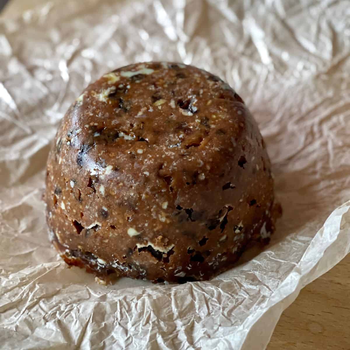 Photo of a Christmas Pudding sitting on the greaseproof paper it was previously wrapped in