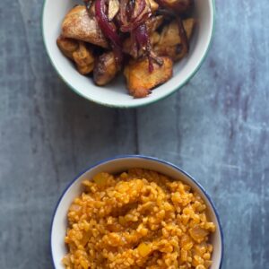 Bulgur Pilaf and Chicken seen from above in their own separate bowls over a steel blue surface