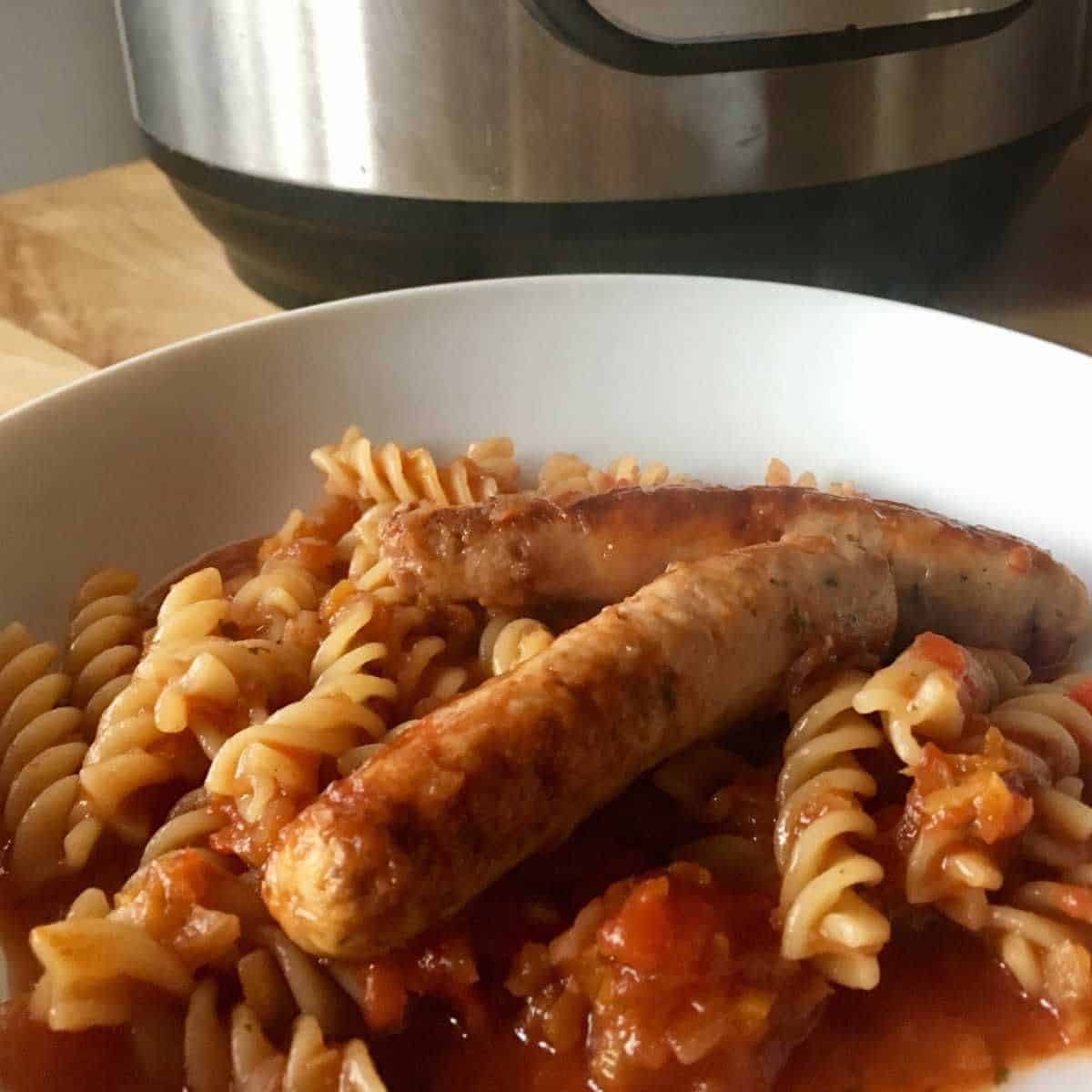 Photo of the sausage and tomato pasta made with fusilli seen with an Instant Pot Duo in the background
