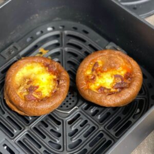 Two mini Yorkshire puddings loaded with cheese and chorizo seen from above inside the drawer of the Instant Vortex air fryer