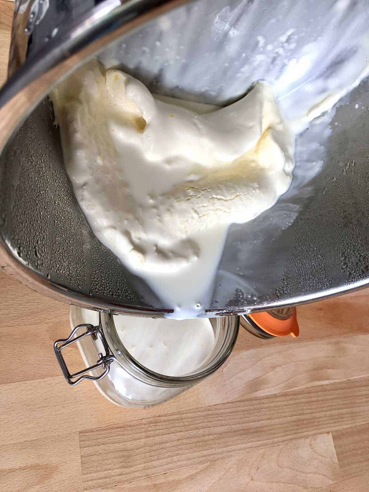 Photo of the moment when the whey is being drained from the inner pot into a glass jar