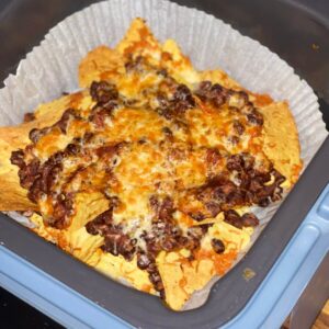 The Quick Chilli for Nachos in the Thermomix seen after air frying over tortilla chips in the Ninja Speedi