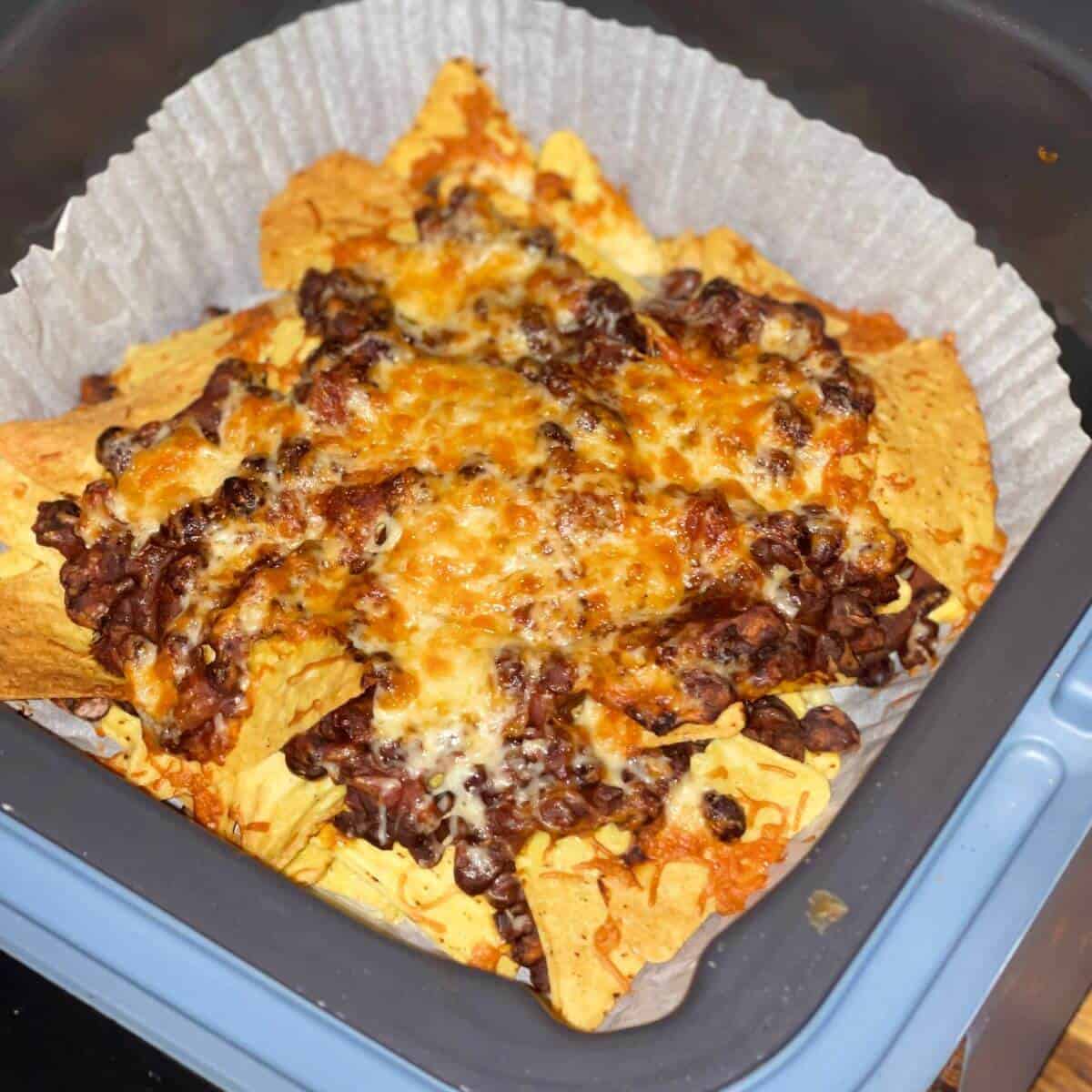 Photo from above of the Quick Chilli for Nachos in the Thermomix seen after air frying over tortilla chips in the Ninja Speedi