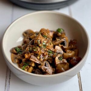 Close-up of the Baharat Mushrooms served in a bowl that's beige on the inside and grey on the outside
