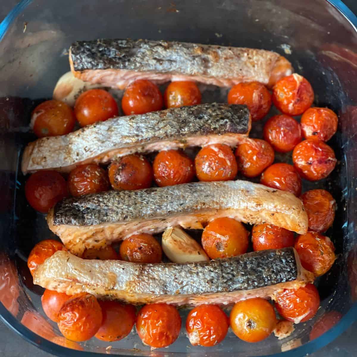 Photo of the salmon fillets and cherry tomatoes inside the large glass container of the Ninja Crispi Air Fryer