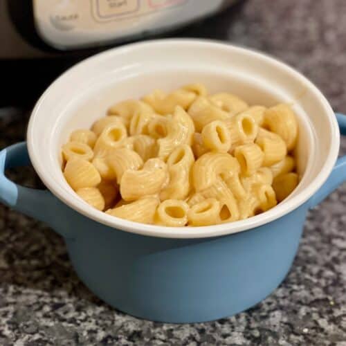 Mac and Cheese inside a blue mini casserole dish with an Instant Pot in the background
