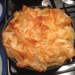 The Chicken and Bacon Filo Pie just out of the oven seen on top of a gas hob